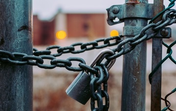 A gate held shut by a padlock and chains.